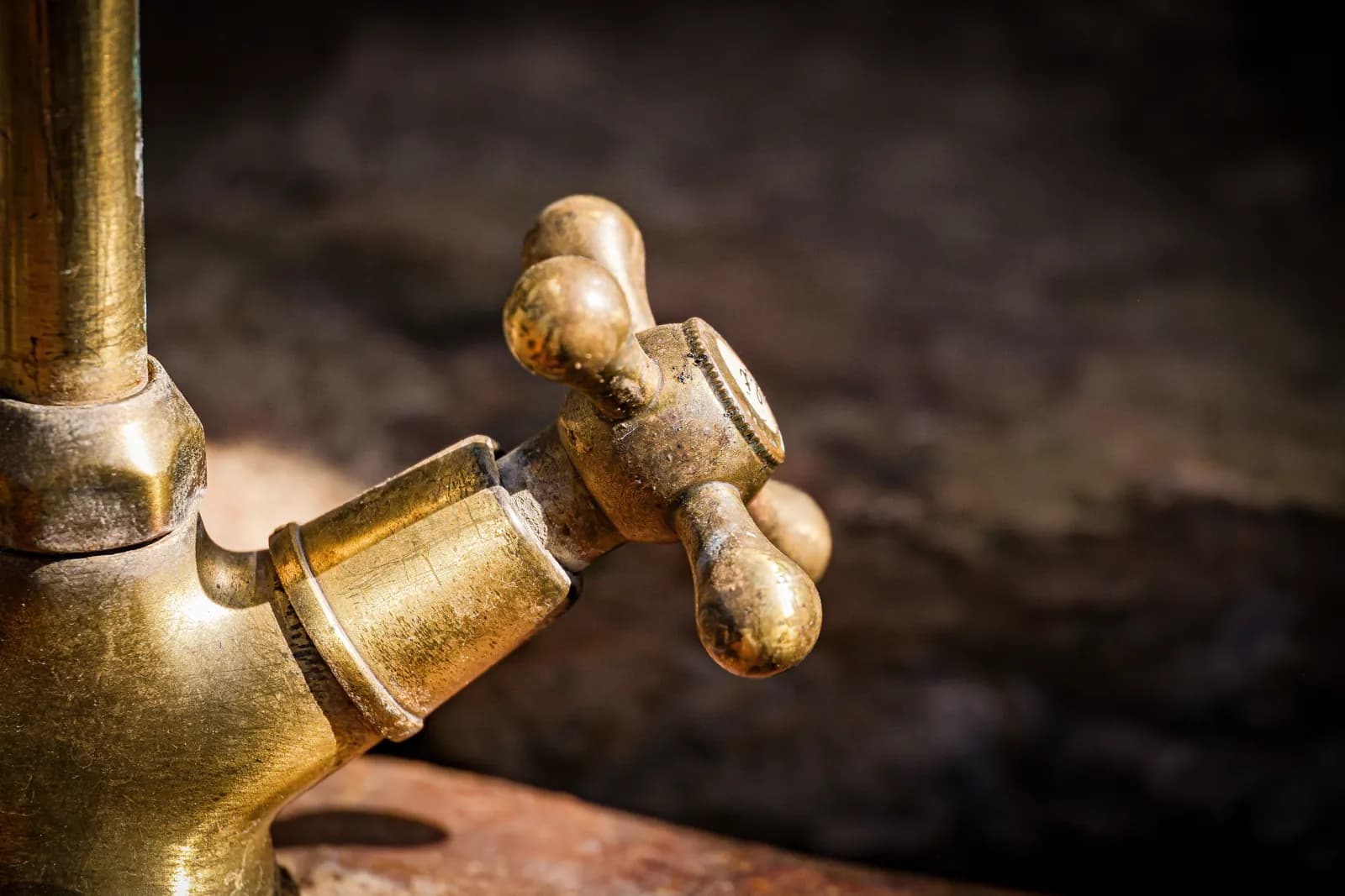 Close-up of an aged brass faucet handle with heavy surface corrosion