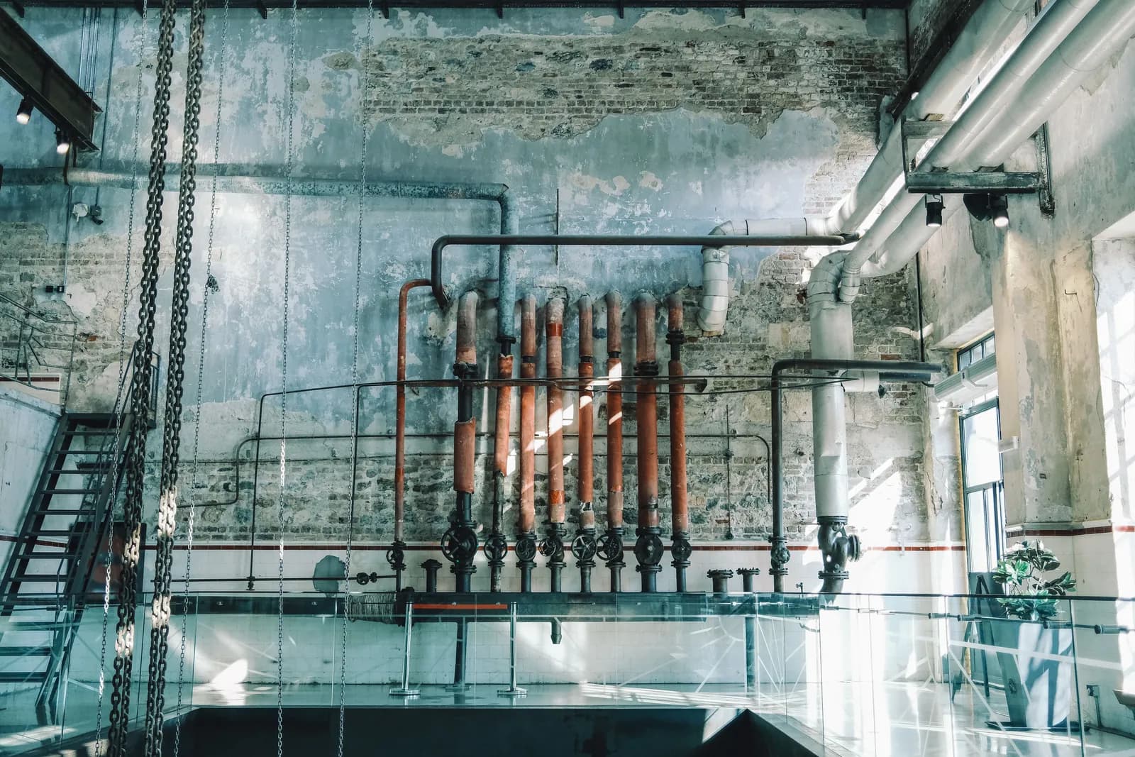 Vintage metal pipework running along a brick wall