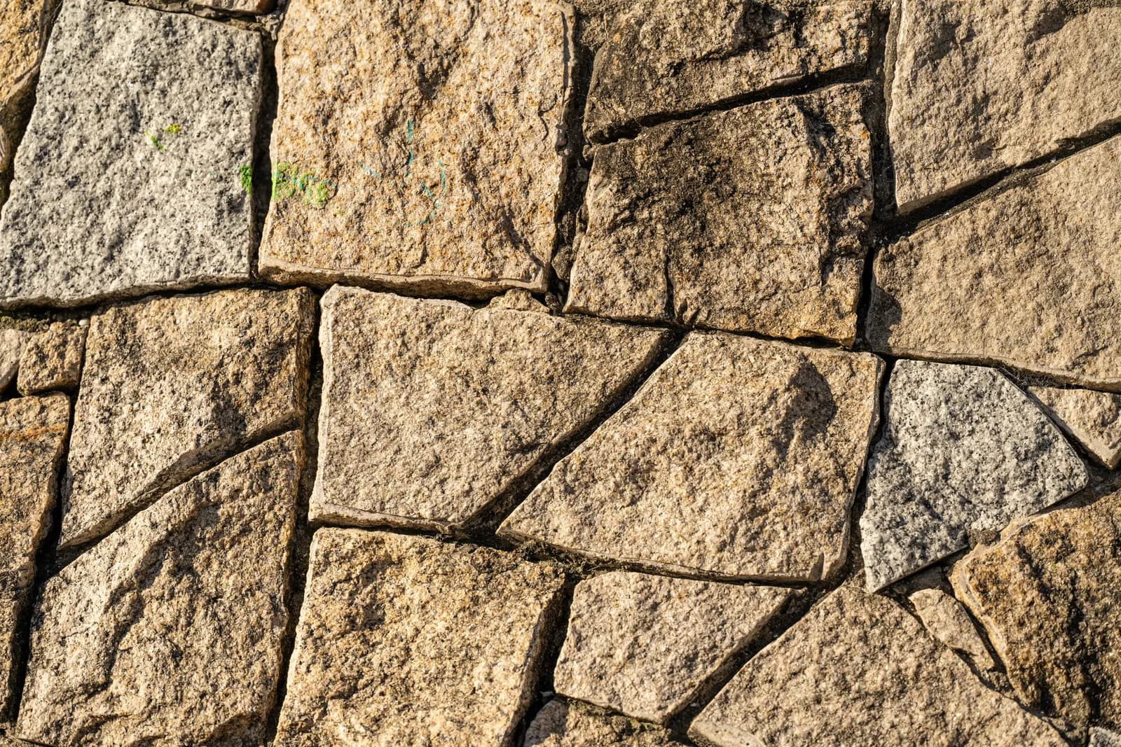 A textured stone and concrete wall surface