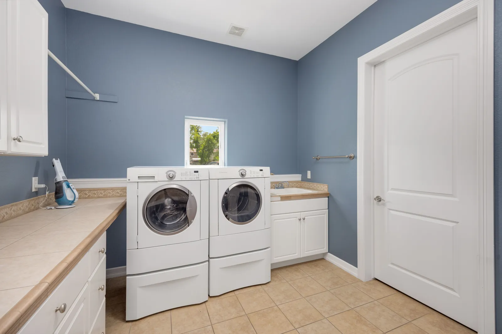 A clean laundry room with appliances along one wall