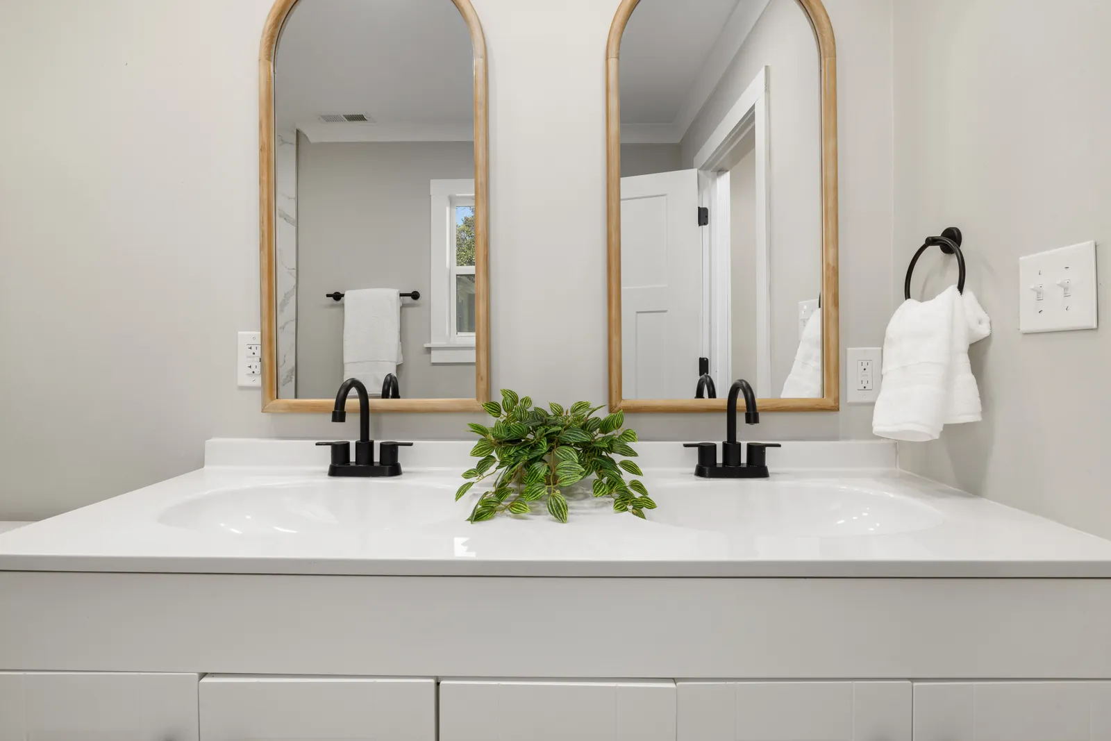 A bathroom vanity with twin basins and mirrors