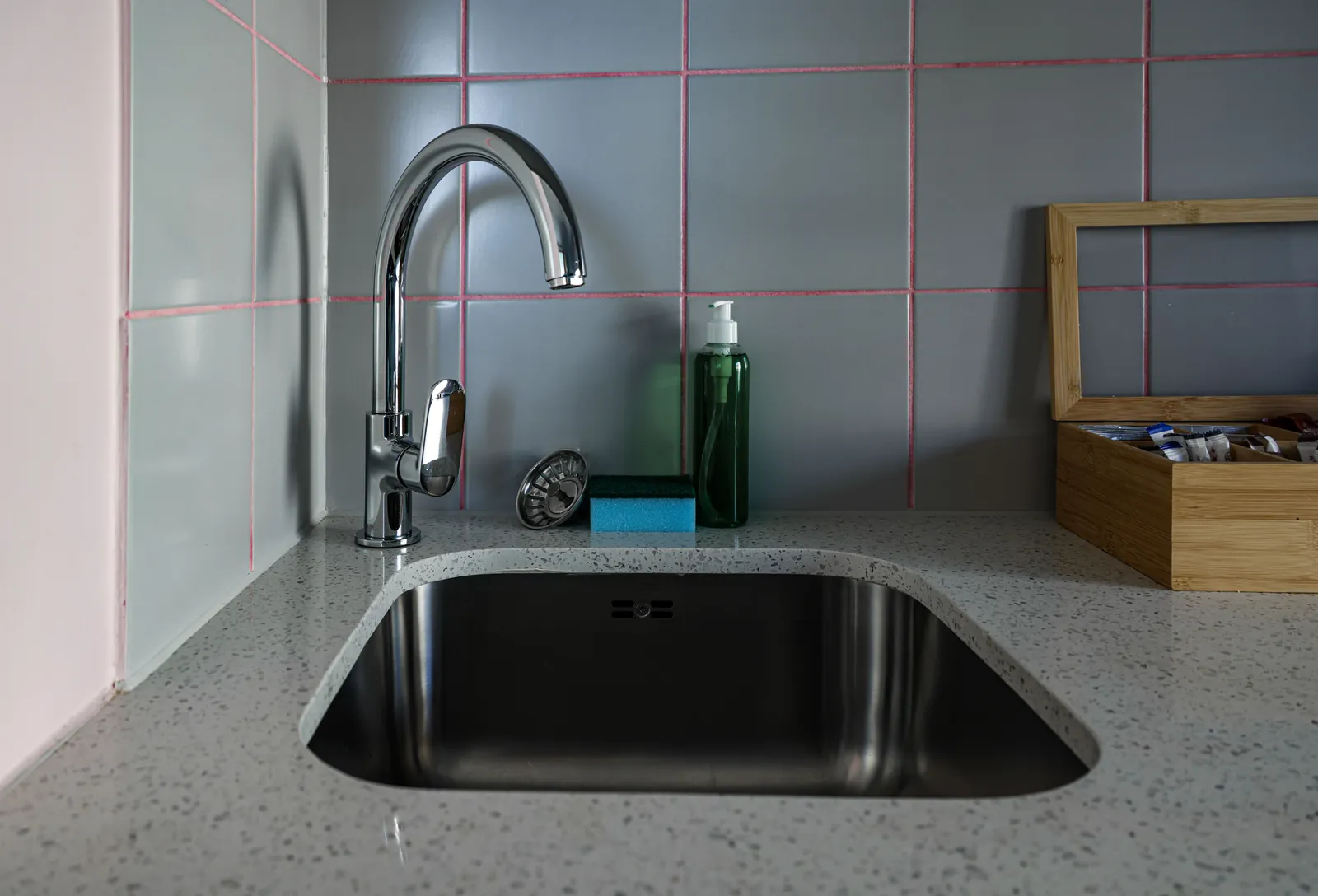A kitchen sink with a chrome faucet and countertop