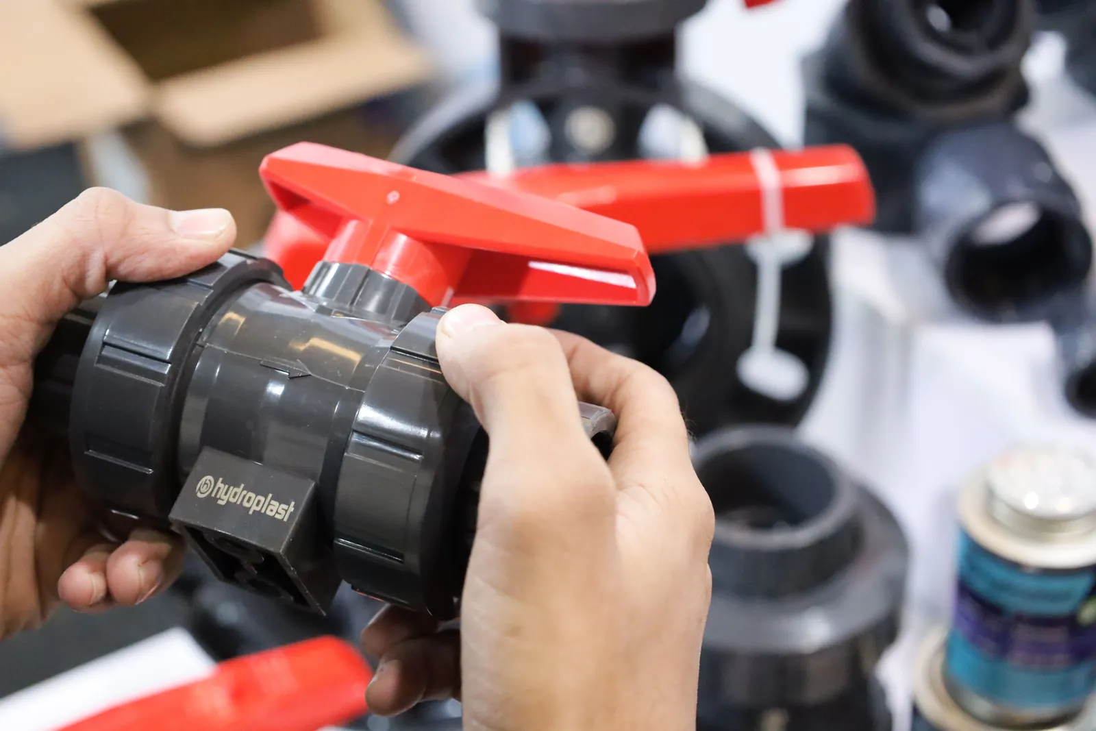 Hands examining a plastic industrial valve