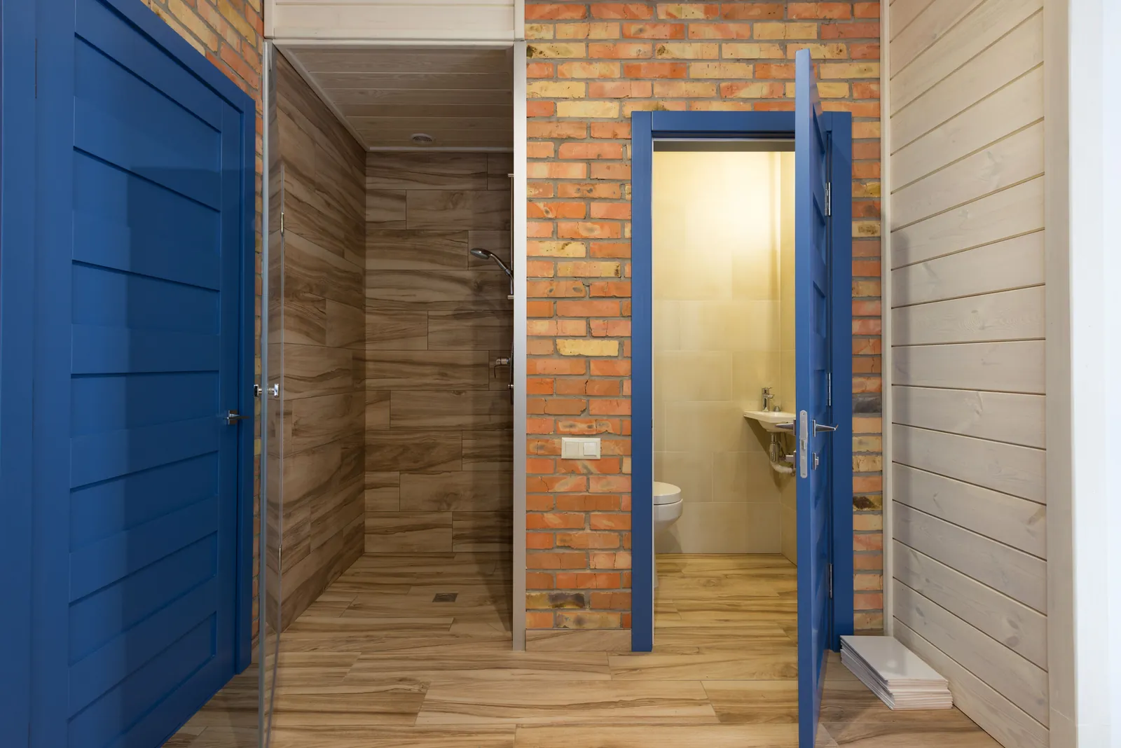 Close-up of the base of a white toilet on a wood-plank bathroom floor