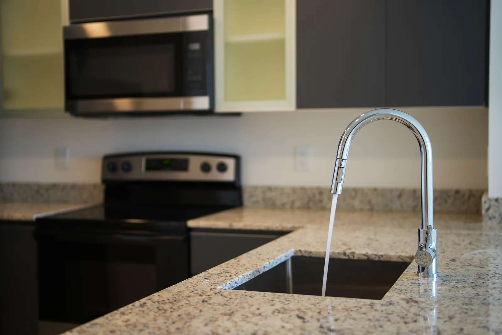A kitchen faucet on a granite countertop