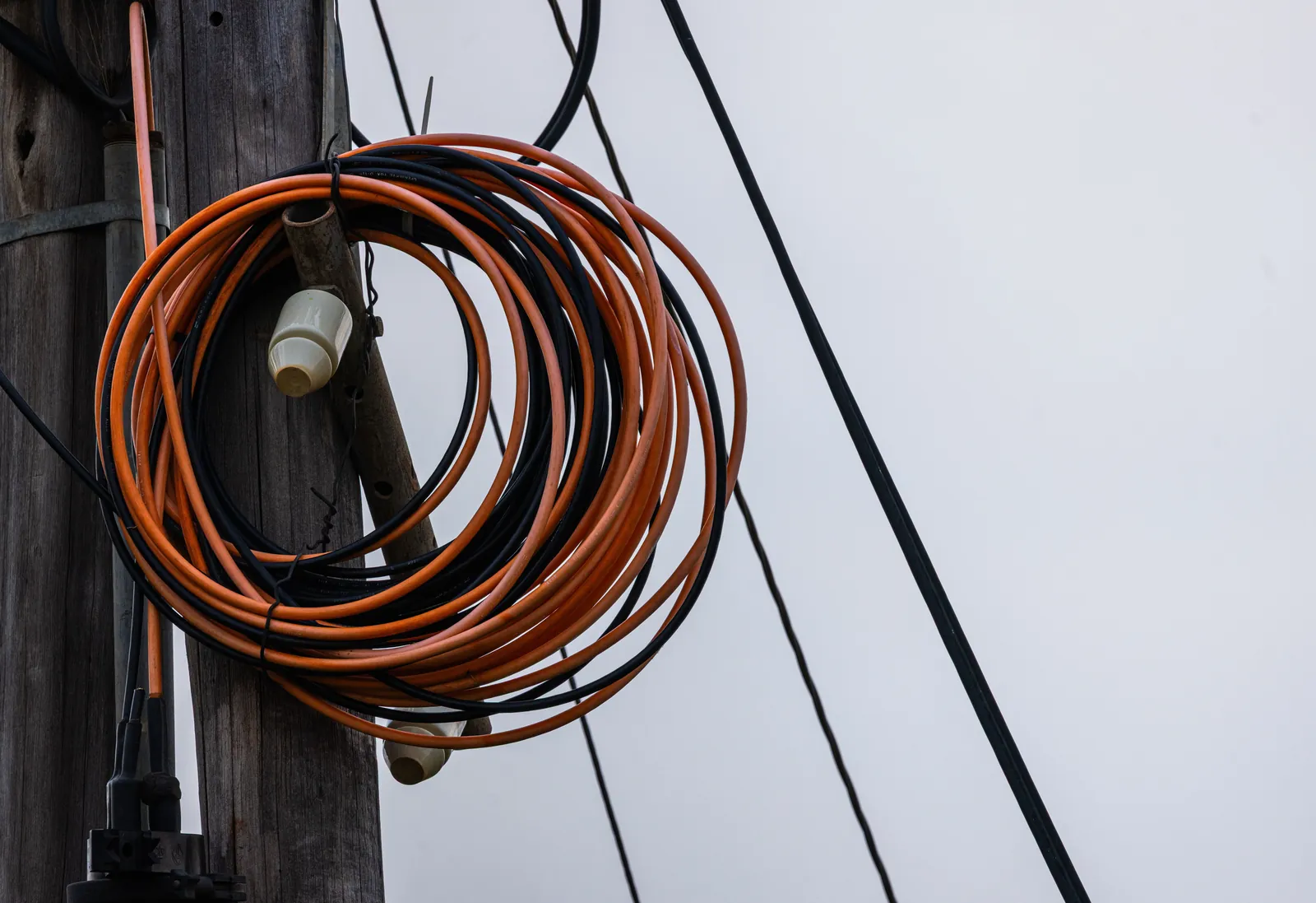 A coiled steel cable lying on a concrete surface