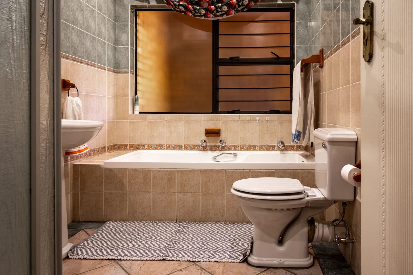 A white toilet next to a bathtub in a tiled bathroom