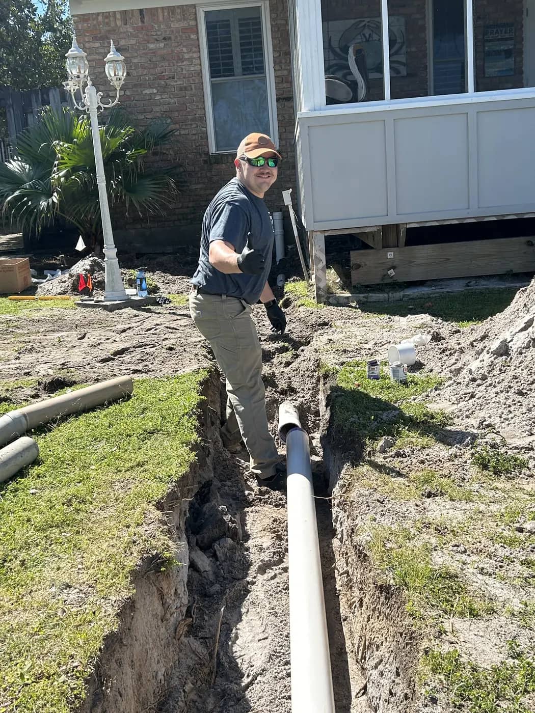 Underground residential water-line work Streamlined Plumbing technician beside newly placed underground residential water piping.