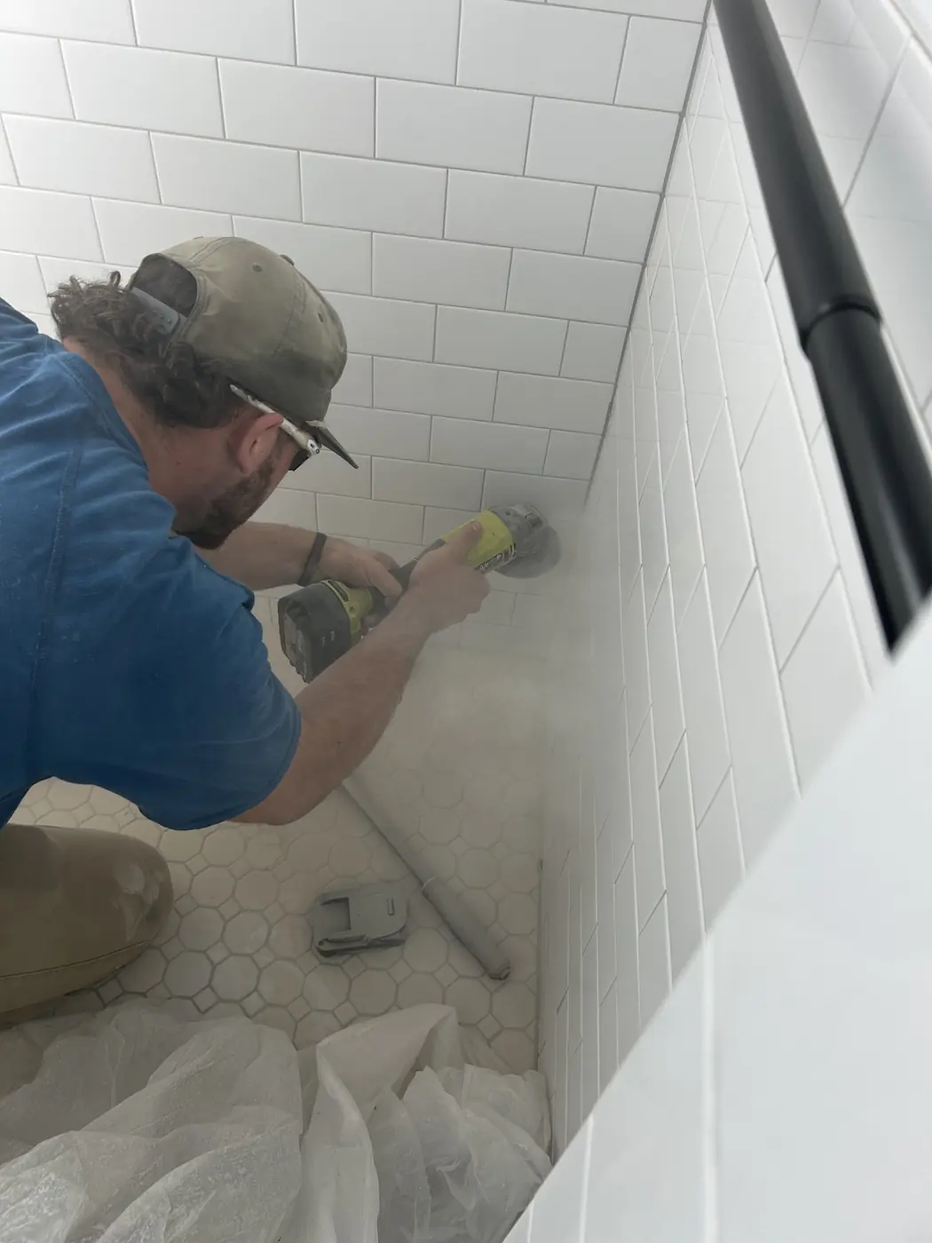 Tile shower fixture installation Streamlined Plumbing technician installing a fixture in a white tile shower.