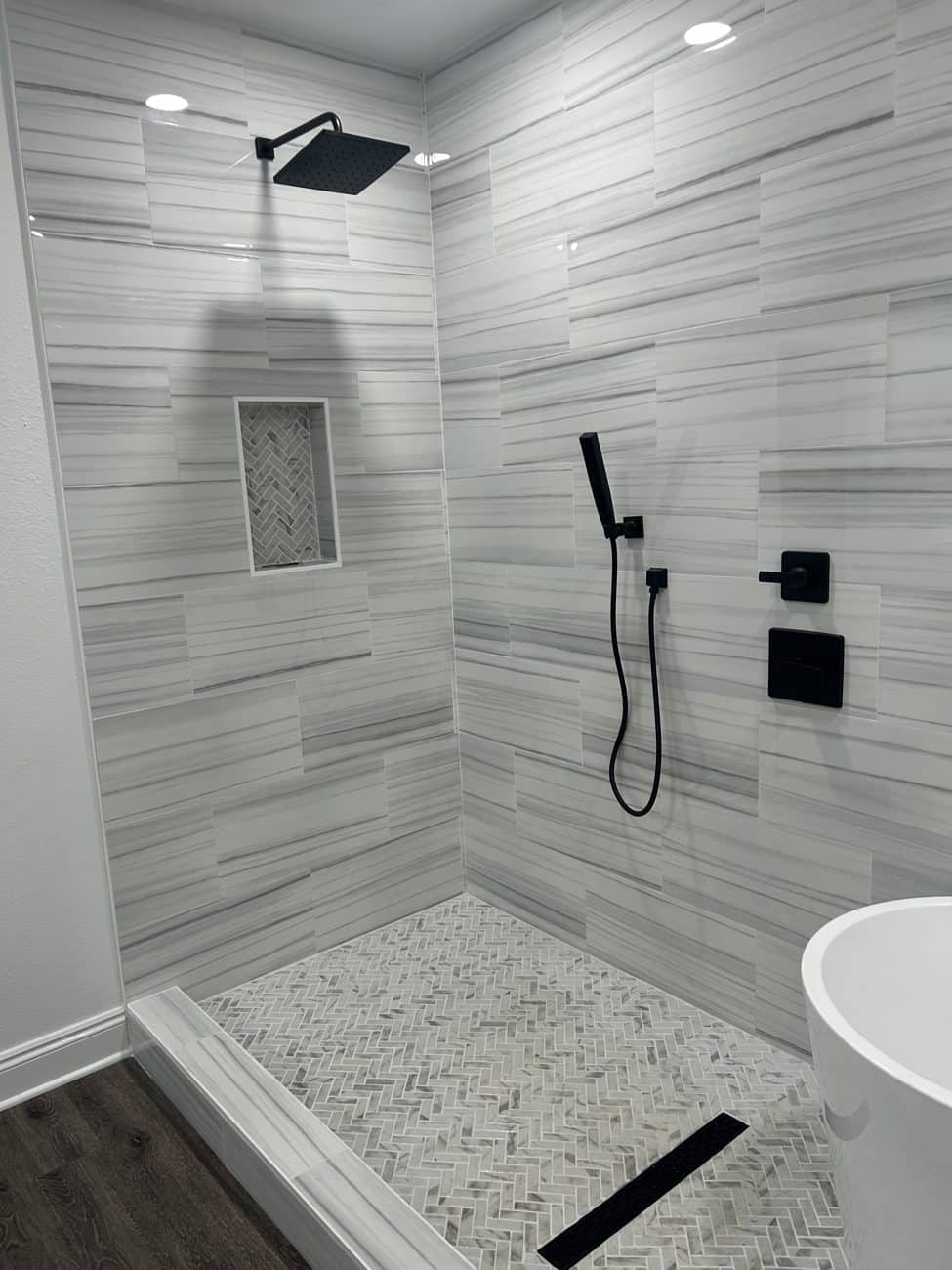 Finished walk-in tile shower with black fixtures in a Gulf Coast vacation rental