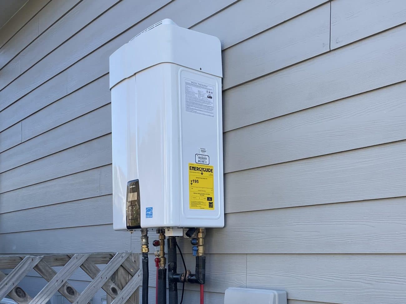 Exterior wall-mounted tankless water heater installed by Streamlined Plumbing on a Baldwin County, Alabama home.
