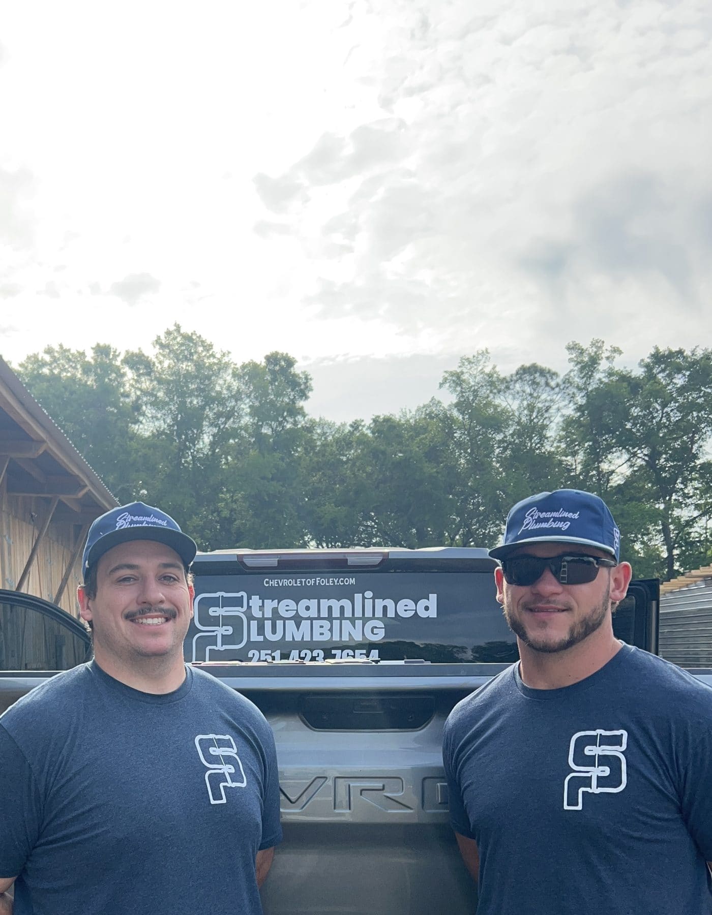 Brandon Byrd and his Streamlined Plumbing business partner standing in front of a branded work truck.