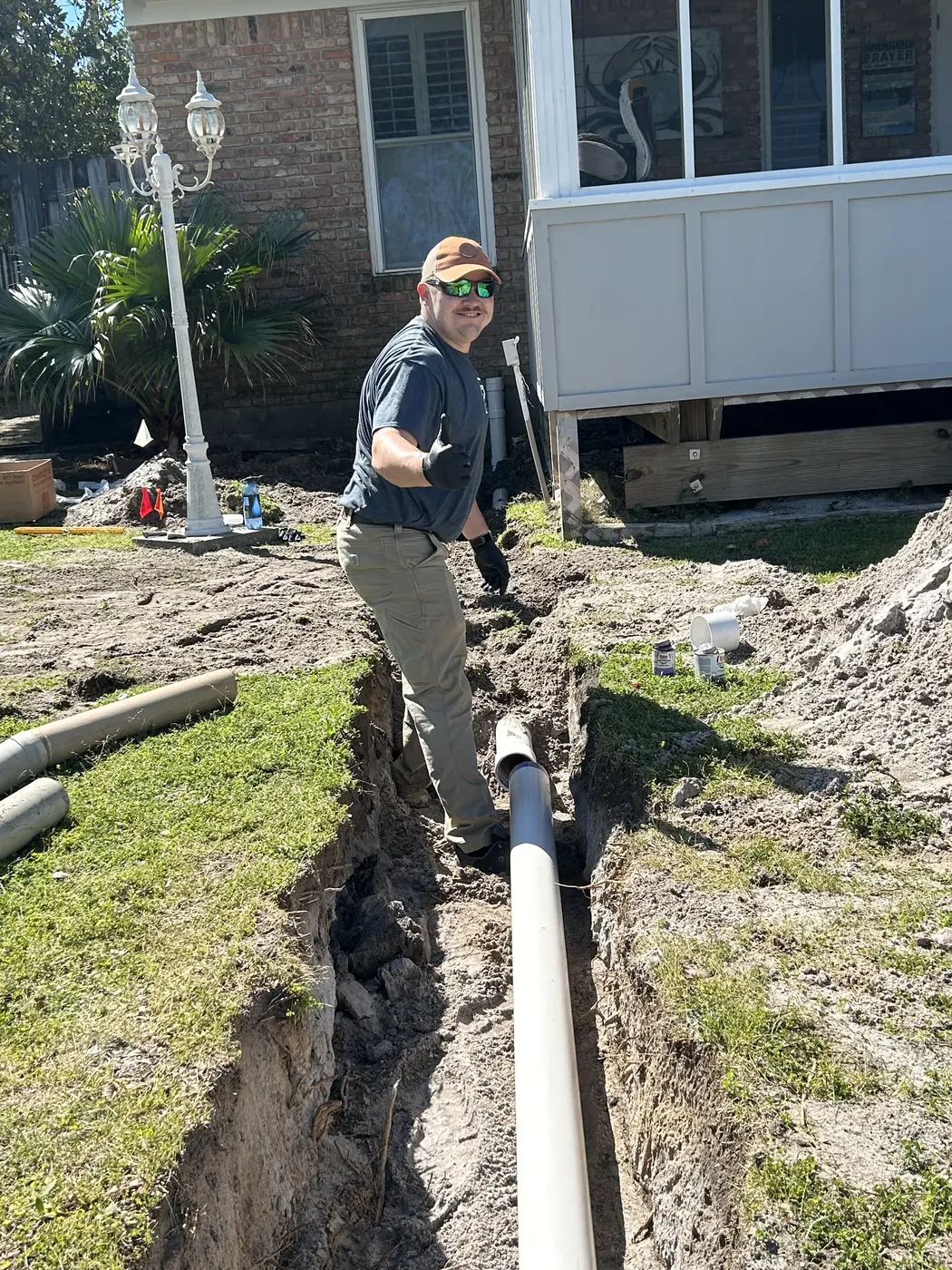 Streamlined Plumbing technician beside newly placed underground residential water piping.