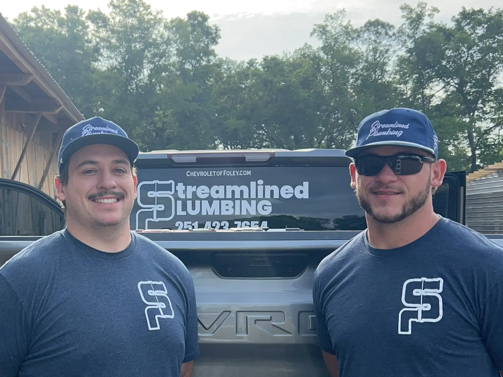 Streamlined Plumbing crew and branded work truck Brandon Byrd and his Streamlined Plumbing business partner standing in front of their branded work truck.